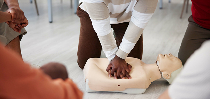 Person performs CPR with a mannequin