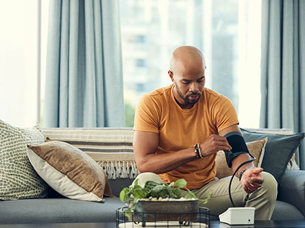 man with high blood pressure checking his numbers on a home monitor