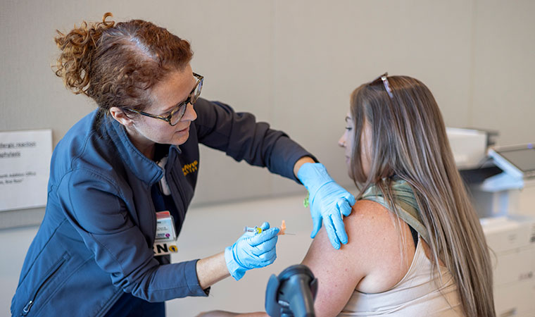 Nurse giving woman a flu or covid vaccine