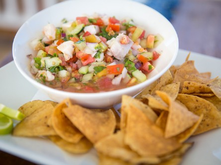 A bowl of ceviche and tortilla chips on the side