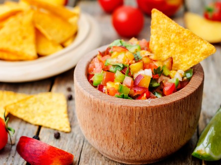 A bowl of salsa and a tortilla chip