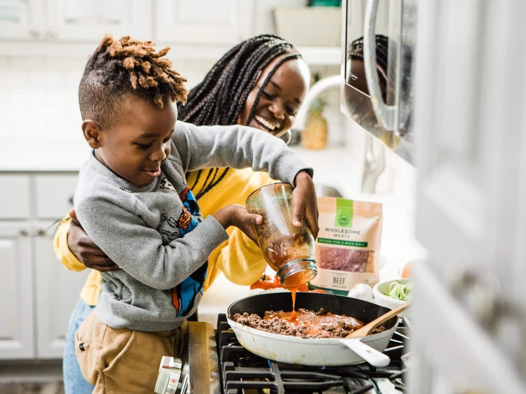 kid making pasta at stove