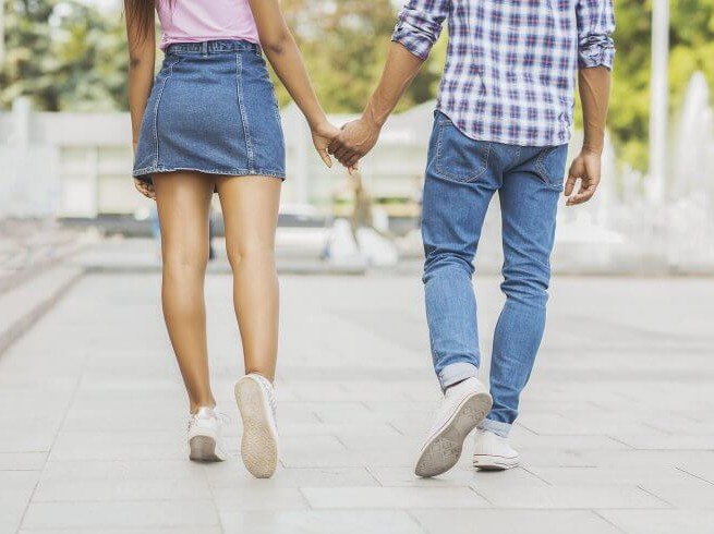 people walking away holding hands