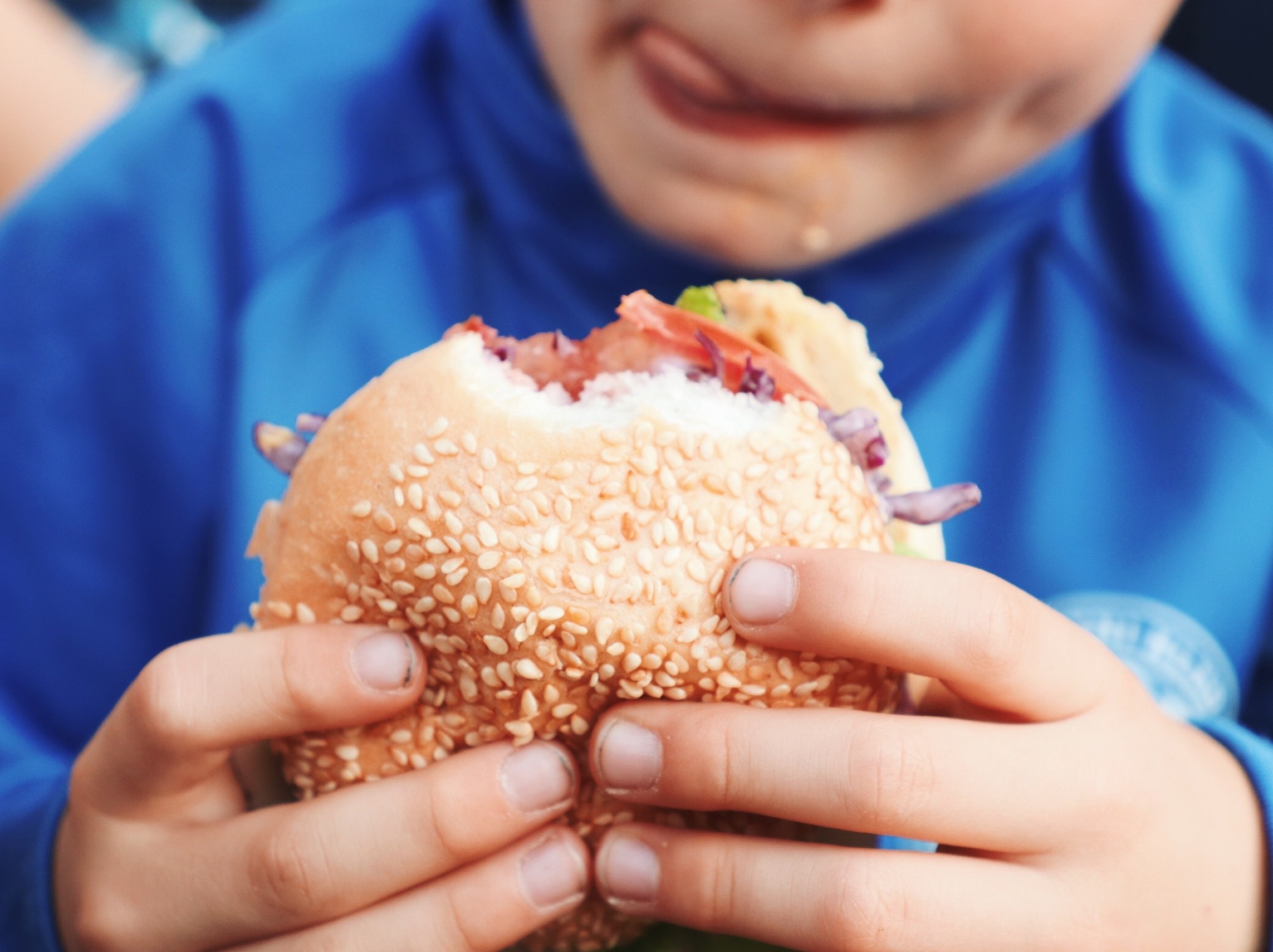 child holding hamburger