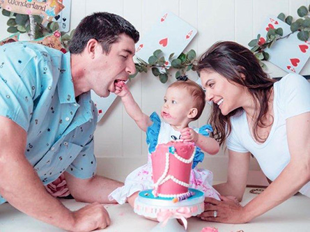 Odette and her family celebrating her birthday with a pink cake