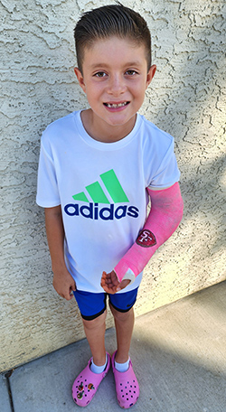 Pediatric ER patient Julian with a pink cast on his left arm