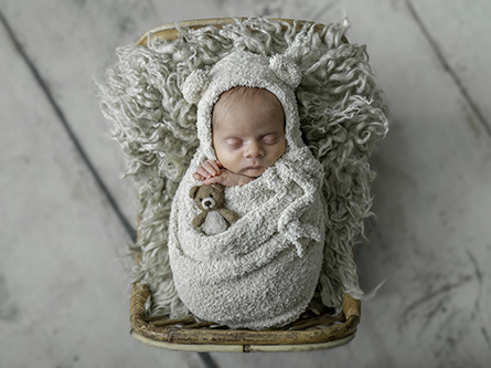Newborn Nixon wrapped in a swaddle