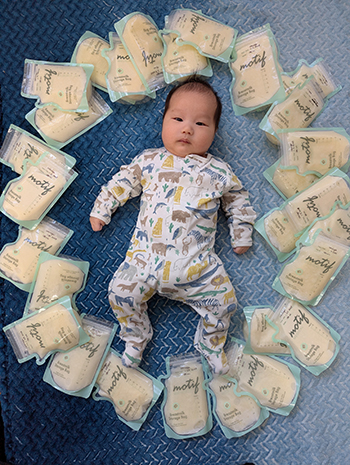 Baby surrounded by milk bag donations