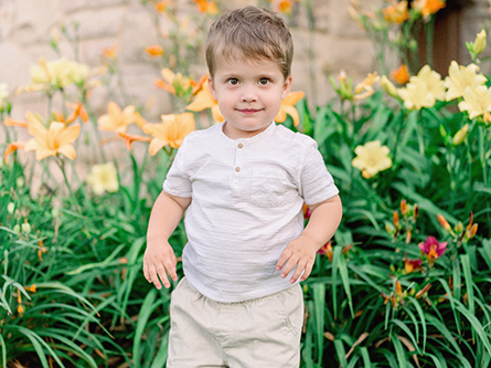 Leo standing in front of yellow flowers