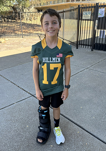 Ryder in his football jersey with a boot cast on his leg