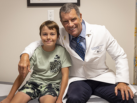 R. Lor Randall, chair of the Department of Orthopaedic Surgery, with pediatric orthopaedic patient Ryder