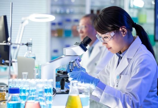 lab employee looking at a microscope