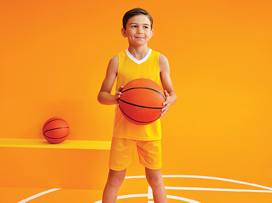 Un paciente pediátrico sosteniendo una pelota de baloncesto