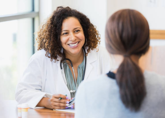 A woman doctor talking with a patient.