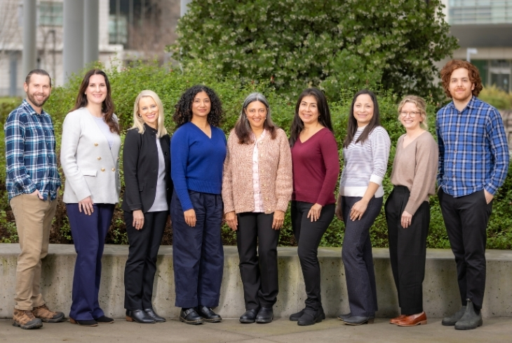 group of nine people, posed outside