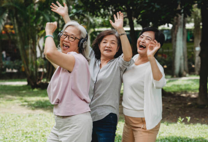 three women dancing at an outdoor park