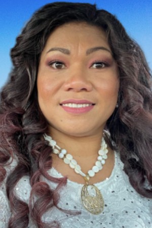 Headshot of Akenese smiling with blue skies in the background