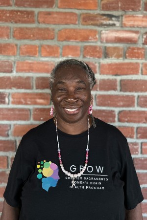 Headshot of Jennifer smiling in front red brick wall