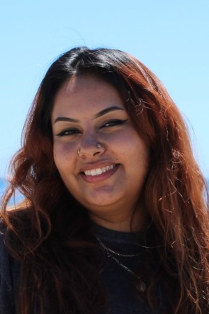 Headshot of Maria smiling under clear blue skies