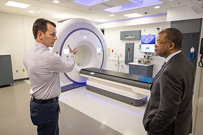 Radiation oncology manager Andrew Harrell shows UC Davis Comprehensive Cancer Center Physician-in-Chief David Tom Cooke the new Radixact system.
