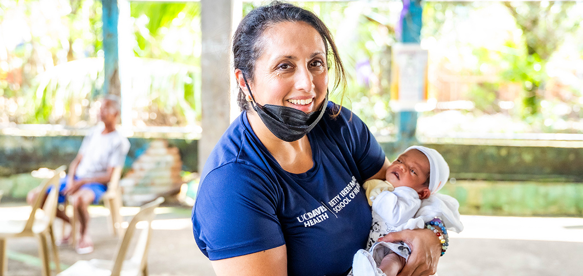 Charleen Singh holding a baby during a recent healthcare outreach visit to the Philippines.