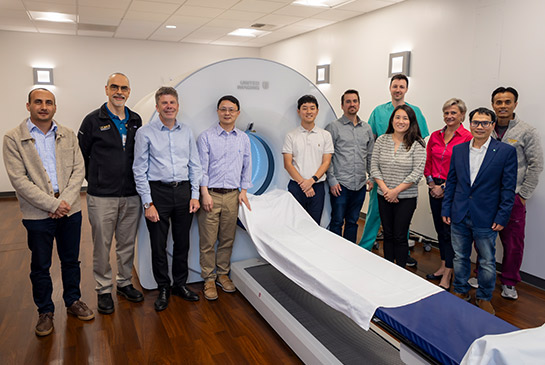 A group of UC Davis team members standing in front of EXPLORER scanner