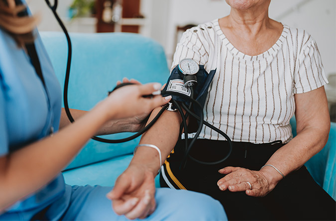 Patient getting blood pressure taken by nurse.