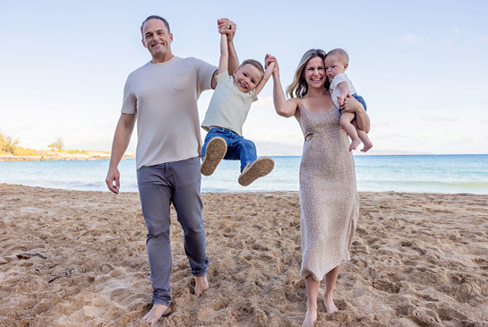 Patient and family smiling at the beach.
