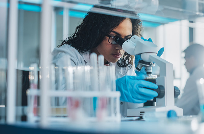 Researcher with microscope.