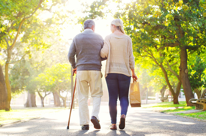 Elderly person walking with younger person.