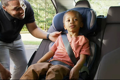 A school-age child in a booster car seat.