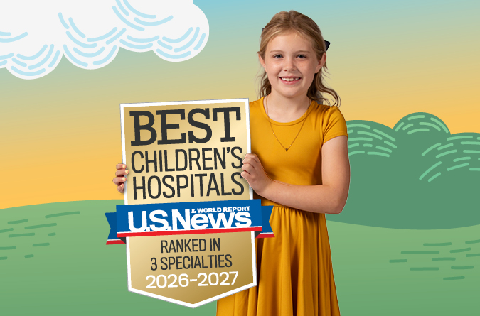 Niño sosteniendo una insignia de mejores Hospitales Infantiles clasificados en 3 especialidades por U.S. News.