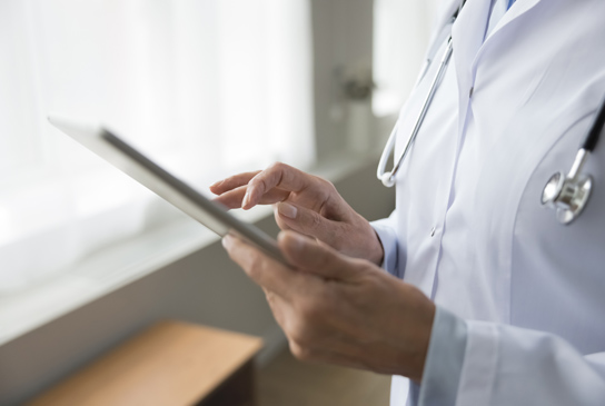 Doctor scribing on a tablet.