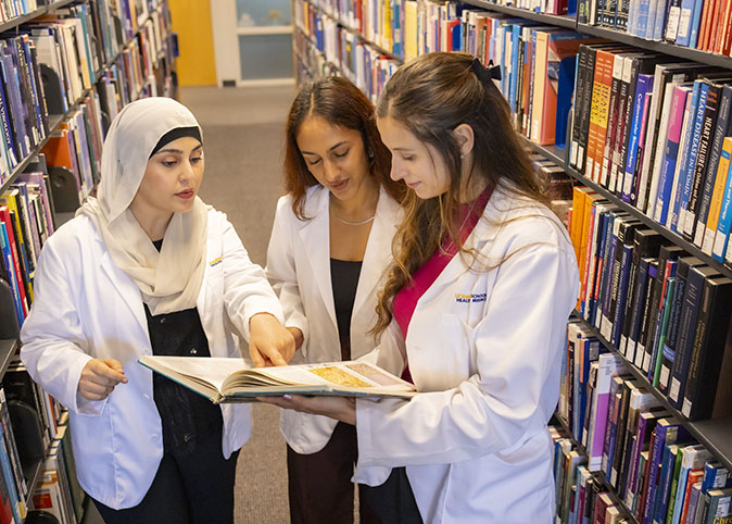 Medical students reading a book together.