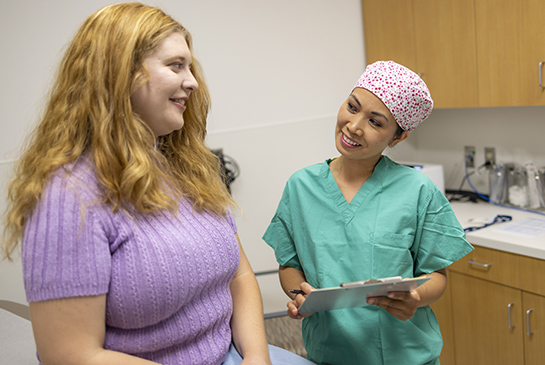 Nurse talking to patient in a doctor's office.