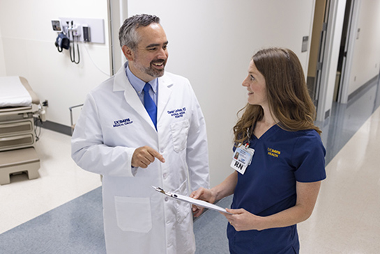 Primary care doctor and nurse practitioner talking in a hallway.