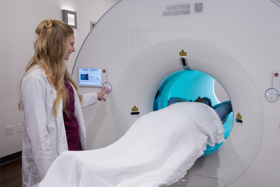 Medical professional observing patient in MRI machine.