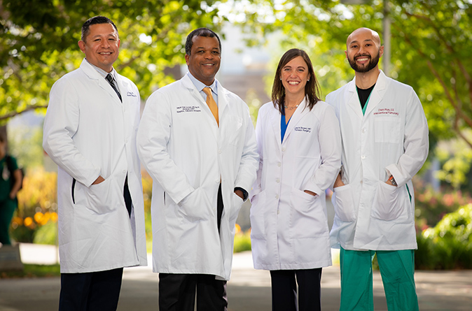 A team of four thoracic surgeons standing together outside