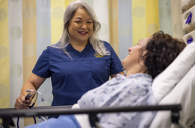 A smiling nurse at an inpatient's bedside