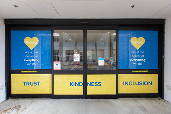 Door sign that reads patients are at the center of everything we do. Trust, kindness, inclusion.