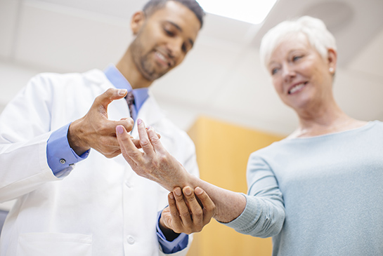 A physician examines a patient's hand