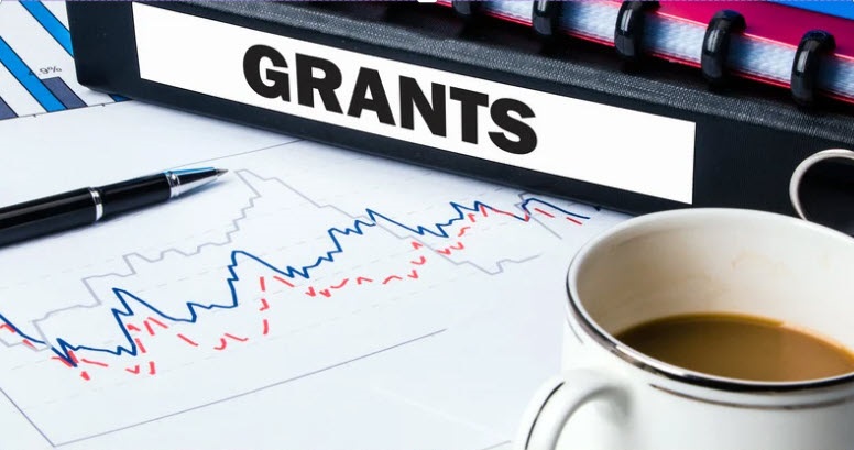 a stack of binders labelled "grants"