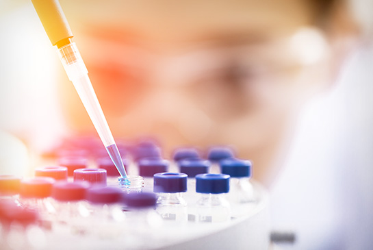 Close up of researcher looking at vials filled with brighly colored fluids