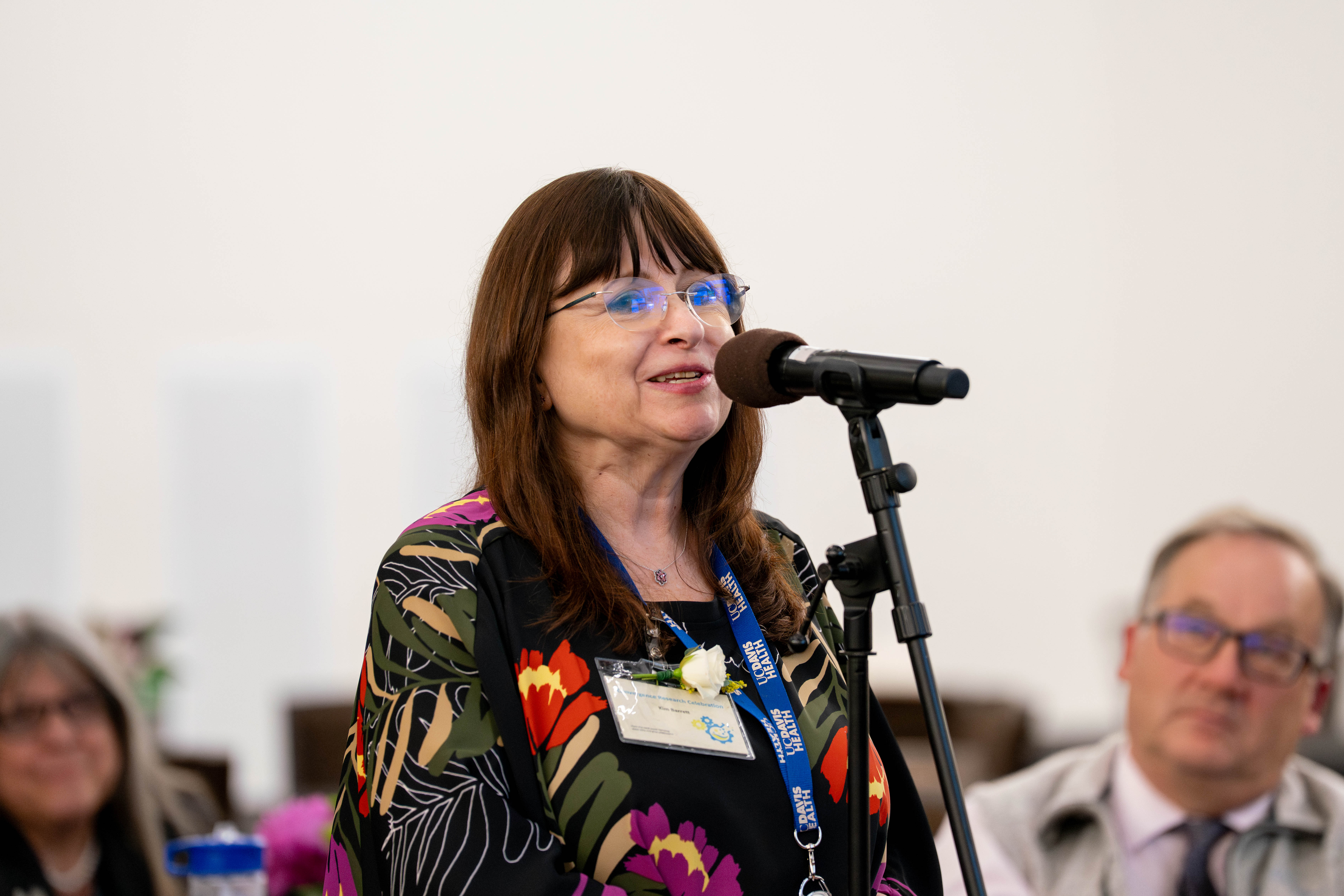 professional image of a woman in a dark jacket speaking at a podium