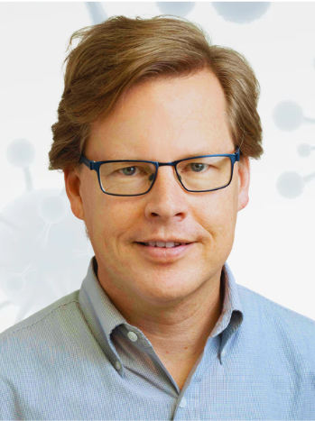 headshot of professional man with light brown hair, glasses and a light blue shirt