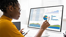 a woman looks at data charts on her computer