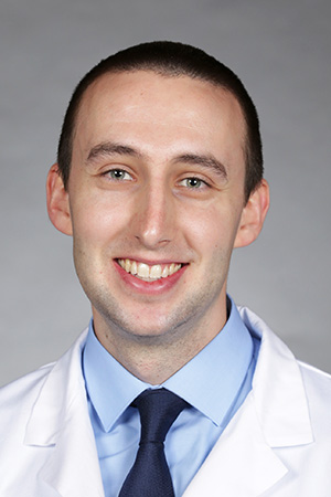 Portrait of medical student Jace Decker in white coat and smiling