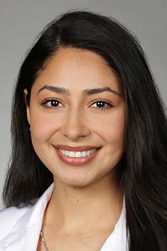 Portrait of medical student Cristina Batarse in white coat and smiling