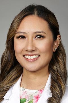 Portrait of medical student Jacklin Ha in white coat and smiling