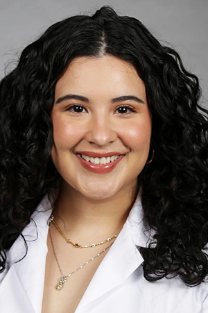 Portrait of medical student Jennifer Becerra in white coat and smiling